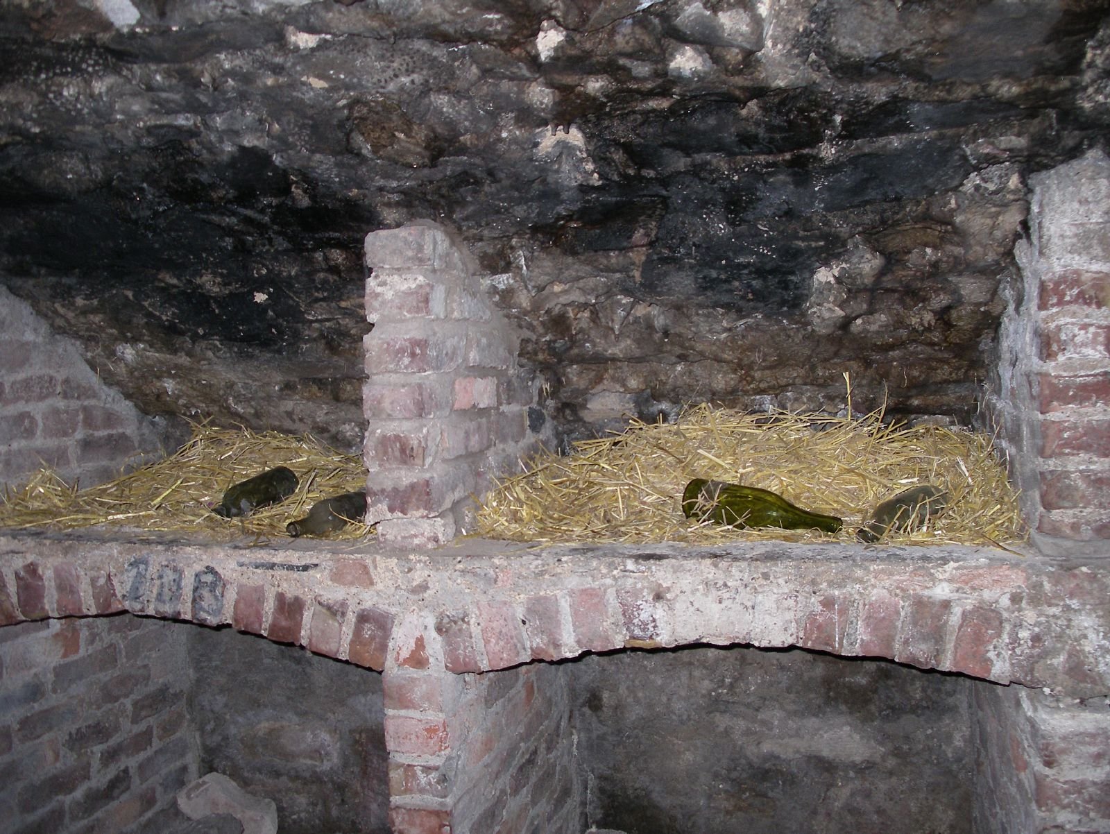Vault alcove with straw and old bottles in the Edinburgh Vaults
