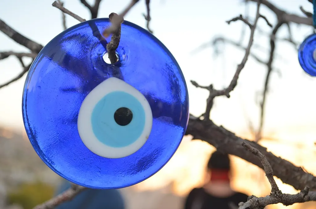 Evil eye meaning — a blue glass nazar amulet disc (Wikimedia Commons)